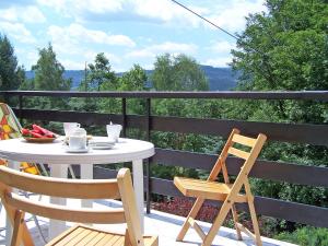 a table and chairs on a balcony with a view of the mountains at Chalet Partecznik by Interhome in Wisła