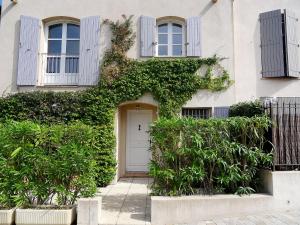 a white house with a white door and ivy at Holiday Home Les Migraniers by Interhome in Grimaud