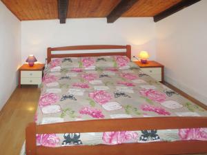 een slaapkamer met een bed met roze rozen erop bij Apartment Lukeni-1 by Interhome in Vinjerac