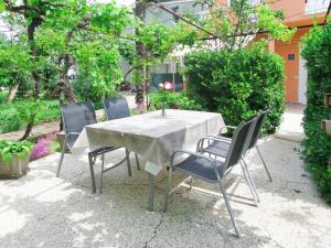 a table and chairs in a garden with trees at Holiday Home Marijana by Interhome in Sukošan