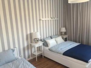 a bedroom with a bed and two tables with lamps at Apartment Family by Interhome in Świnoujście