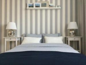 a bedroom with a bed and two tables with lamps at Apartment Family by Interhome in Świnoujście +5 photos