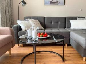 a living room with a couch and a table with fruit on it at Apartment Family by Interhome in Świnoujście