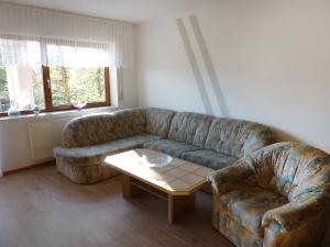 a living room with a couch and a coffee table at Apartment Schwarzwaldblick-13 by Interhome in Obertal