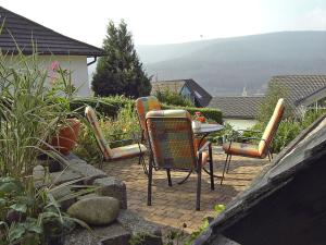 a patio with three chairs and a table on a patio at Apartment Blank by Interhome in Titisee-Neustadt