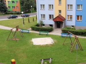 a park with swings and benches in front of a building at Apartment Ewa by Interhome in Szklarska Poręba