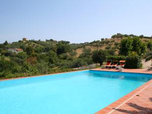 a swimming pool with two chairs and a mountain at Holiday Home Breda by Interhome in Citta' Sant'Angelo