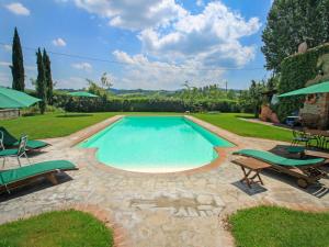 a swimming pool with two lawn chairs and a patio at Holiday Home Tara by Interhome in Laterina