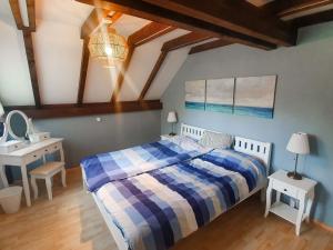 Un dormitorio con una cama azul y blanca y un escritorio en Holiday Home Ferienpark Vorauf-4 by Interhome, en Molberting