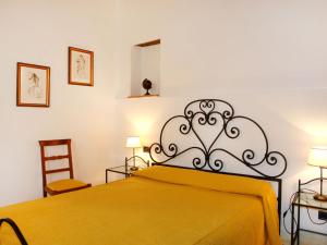a bedroom with a bed with a yellow blanket at Apartment I Ceneruzzi-2 by Interhome in Gambassi Terme