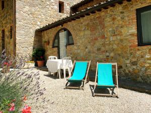 deux chaises bleues assises devant un bâtiment dans l'établissement Apartment I Ceneruzzi-2 by Interhome, à Gambassi Terme