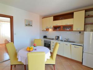a kitchen with a table with a bowl of fruit on it at Apartment Viktor-2 by Interhome in Trogir