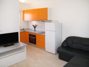 a kitchen with orange cabinets and a white refrigerator at Apartment Andjelka-1 by Interhome in Trogir