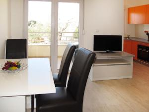 a kitchen with a dining room table with a television at Apartment Andjelka-1 by Interhome in Trogir