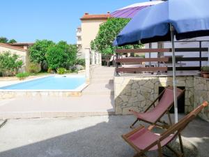 a chair and an umbrella next to a swimming pool at Holiday Home Franko 1 - MDN182 by Interhome in Ližnjan