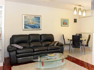 a living room with a black leather couch and a glass table at Holiday Home Edo - BRC601 by Interhome in Nerežišće