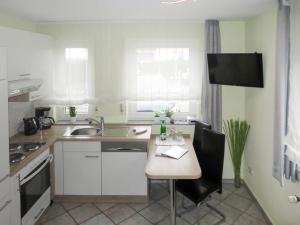 a kitchen with a sink and a table with chairs at Apartment Weinand by Interhome in Kottenborn