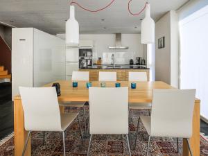 a dining room with a wooden table and white chairs at Apartment Melina by Interhome in Laax