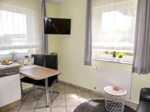 uma cozinha com uma mesa e uma televisão na parede em Apartment Weinand by Interhome em Kottenborn