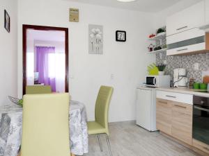 eine Küche mit einem Tisch und Stühlen im Zimmer in der Unterkunft Apartment Borovina - KOR204 by Interhome in Prigradica