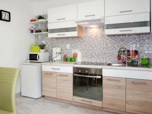 una cocina con armarios blancos y fregadero en Apartment Borovina - KOR204 by Interhome, en Prigradica