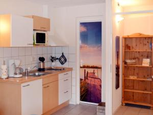 a kitchen with white cabinets and a view of the ocean at Apartment Tossens-8 by Interhome in Butjadingen OT Tossens