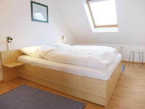 ノルトダイヒにあるApartment Frisiastrasse-3 by Interhomeのベッドルーム1室(白いシーツ付きのベッド1台、窓付)