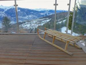 a wooden bench sitting on top of a deck with mountains at Apartment Clair-Azur B 65 by Interhome in Randogne