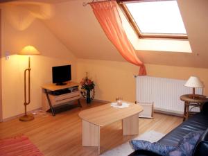 a living room with a skylight and a couch and a table at Apartment Ferienhof Peters-1 by Interhome in Funnixer Neue Mitteldeich