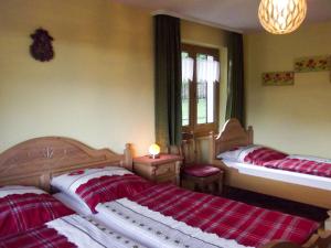 2 Betten in einem Schlafzimmer mit roten und weißen Decken in der Unterkunft Apartment Tillisch by Interhome in Sasbachwalden