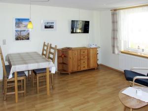 een keuken en eetkamer met een tafel en stoelen bij Apartment Am Strom-4 by Interhome in Ummanz