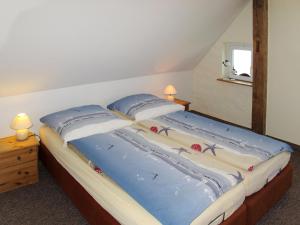 a bedroom with a bed with blue sheets and pillows at Apartment Am Strom-4 by Interhome in Ummanz