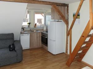 a kitchen with a refrigerator and a couch in a room at Apartment Am Strom-4 by Interhome in Ummanz