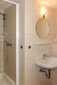 a bathroom with a shower and a sink and a mirror at Apartment Am Strom-4 by Interhome in Ummanz