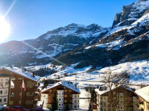 a resort with snow covered mountains in the background at Apartment Ringstrasse - Utoring-3 by Interhome in Leukerbad