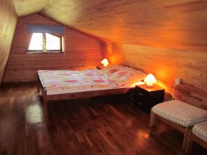 um quarto com uma cama num chalé de madeira em Holiday Home Mały Domek by Interhome em Darłowo