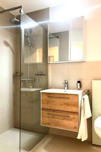 a bathroom with a sink and a shower with a mirror at Apartment Ringstrasse - Utoring-3 by Interhome in Leukerbad