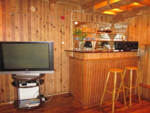 a television sitting in a bar with two stools at Holiday Home Mały Domek by Interhome in Darłowo