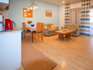 eine Küche und ein Wohnzimmer mit einem Tisch und Stühlen in der Unterkunft Apartment Windrose by Interhome in Burhave
