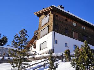 a building in the snow with trees in front of it at Apartment Chesa Sül Muot by Interhome in St. Moritz