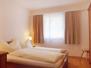 een slaapkamer met een wit bed en een raam bij Apartment Chesa Sur Val 22 by Interhome in St. Moritz