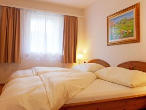 een groot wit bed in een slaapkamer met een raam bij Apartment Chesa Sur Val 22 by Interhome in St. Moritz