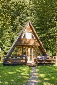 una pequeña casa con un techo triangular en la hierba en Holiday Home Geesthof-8 by Interhome, en Klint