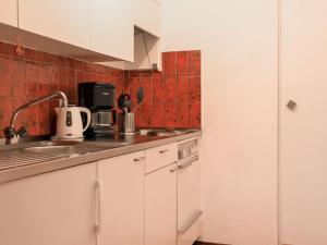 eine Küche mit weißen Schränken und roten Fliesen in der Unterkunft Apartment Chesa Ova Cotschna 205 by Interhome in St. Moritz