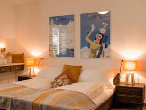 ein Schlafzimmer mit einem Bett mit Plakaten an der Wand in der Unterkunft Apartment Chesa Ova Cotschna 205 by Interhome in St. Moritz