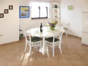 a white table with chairs and a bottle of wine at Apartment Culić-2 by Interhome in Trogir