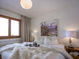 a bedroom with two beds with a furry blanket at Apartment Chesa Ludains 8 by Interhome in St. Moritz