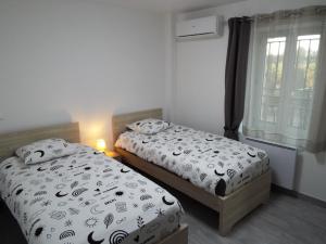 two twin beds in a room with a window at La Maison du Moulin de Tartay in Avignon