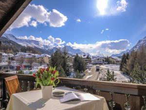 una mesa en un balcón con vistas a las montañas en Apartment Chesa La Sajetta by Interhome en Surlej