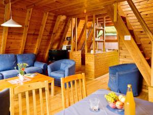 a dining room with a table and blue chairs at Holiday Home Geesthof-8 by Interhome in Klint